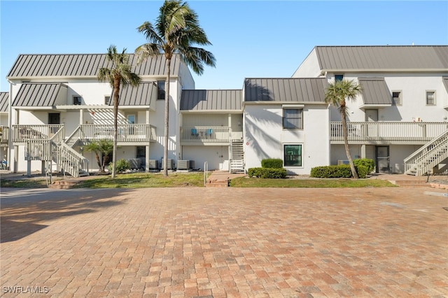 view of property featuring stairway, a residential view, and cooling unit