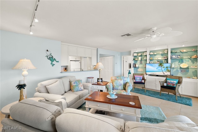 living area featuring light tile patterned floors, visible vents, track lighting, and a ceiling fan