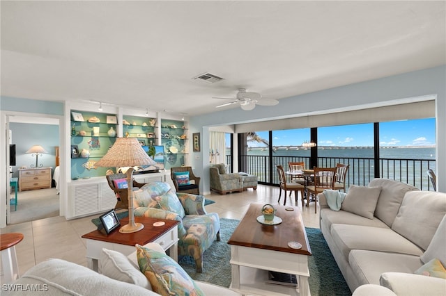 living area featuring tile patterned flooring, visible vents, rail lighting, and ceiling fan