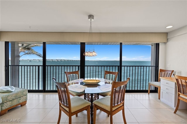 dining room with a water view, an inviting chandelier, and light tile patterned flooring