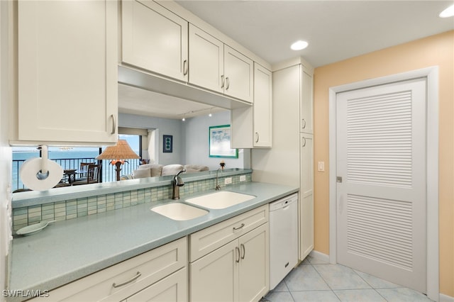 kitchen featuring a sink, white cabinetry, white dishwasher, light countertops, and light tile patterned floors