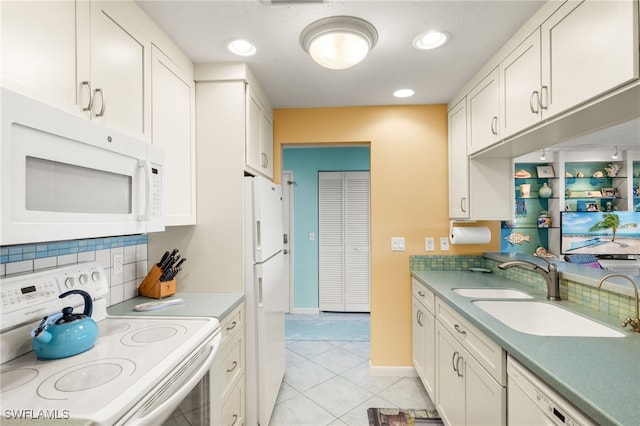 kitchen featuring tasteful backsplash, white cabinets, white appliances, and a sink