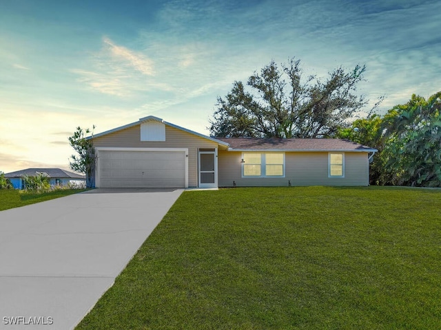 ranch-style home featuring an attached garage, concrete driveway, and a front yard