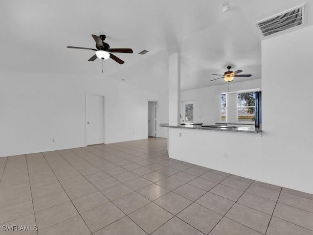 unfurnished living room featuring tile patterned floors, visible vents, a ceiling fan, and vaulted ceiling