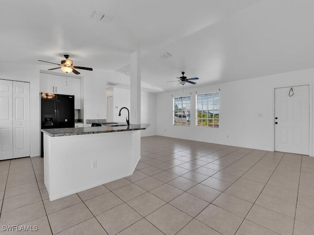 kitchen featuring light tile patterned floors, visible vents, white cabinets, and dark stone counters