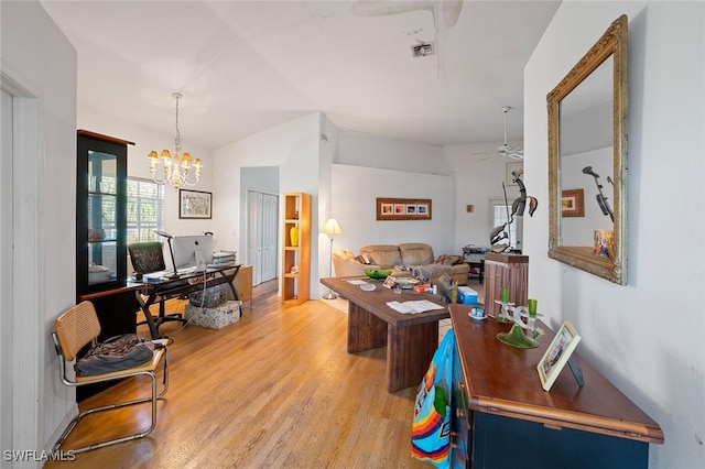 office space with light wood-type flooring, visible vents, ceiling fan with notable chandelier, and lofted ceiling