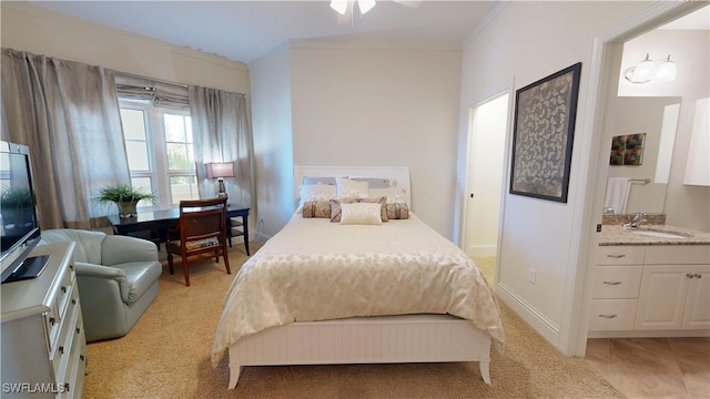 bedroom with ensuite bathroom, light tile patterned floors, a sink, baseboards, and crown molding