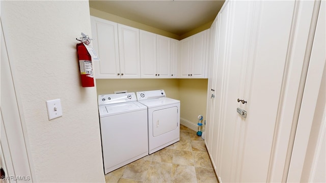 washroom with washing machine and clothes dryer and cabinet space