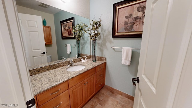 bathroom with visible vents, baseboards, vanity, and toilet