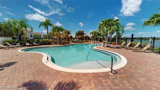 community pool featuring fence and a patio