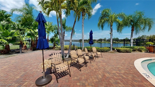 view of patio / terrace with a water view and fence