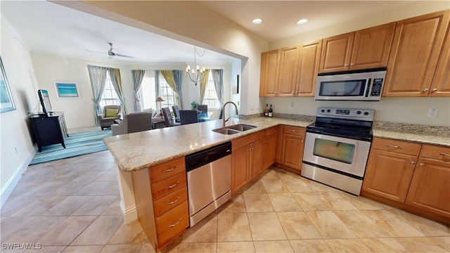 kitchen with light stone counters, a peninsula, stainless steel appliances, a sink, and light tile patterned flooring