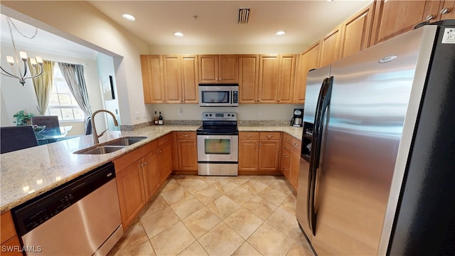 kitchen featuring a notable chandelier, a sink, visible vents, appliances with stainless steel finishes, and light stone countertops