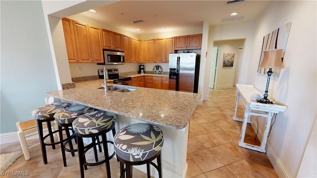 kitchen with visible vents, appliances with stainless steel finishes, a kitchen breakfast bar, a peninsula, and recessed lighting