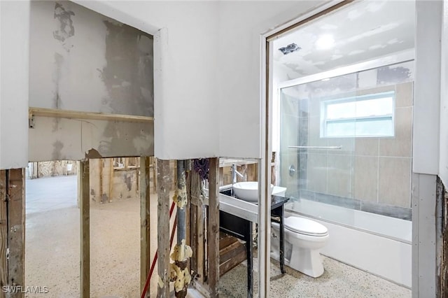 bathroom with toilet, combined bath / shower with glass door, and speckled floor