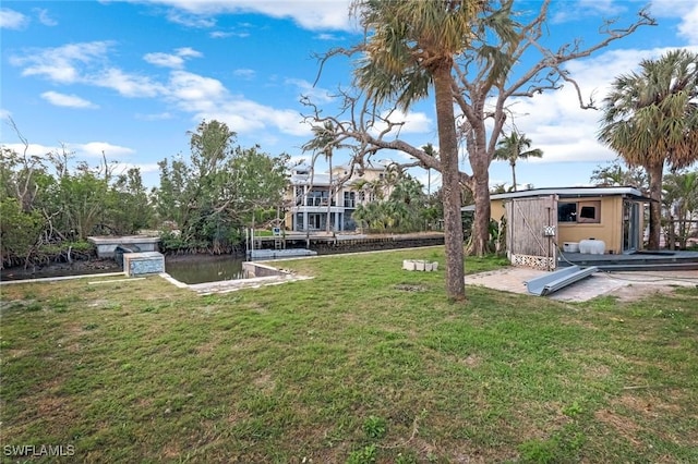 view of yard with a water view, a storage shed, and an outdoor structure