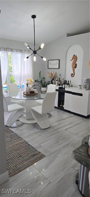 dining area with lofted ceiling and a notable chandelier