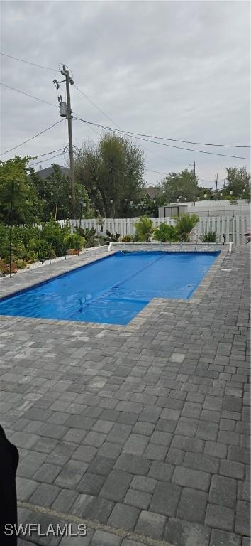 view of swimming pool featuring a patio area, fence, and a fenced in pool