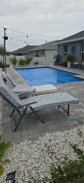 view of swimming pool with a fenced in pool, a patio, and fence