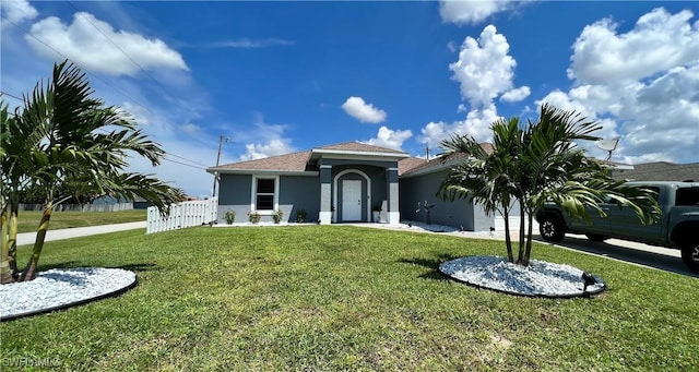 mediterranean / spanish-style home with a garage, fence, a front lawn, and stucco siding