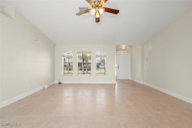 empty room with lofted ceiling, light tile patterned flooring, ceiling fan with notable chandelier, visible vents, and baseboards