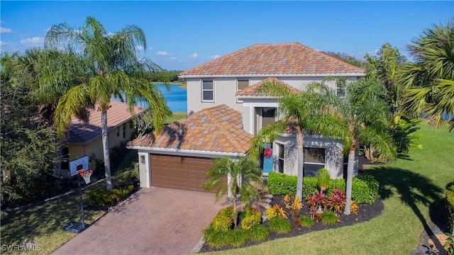 mediterranean / spanish-style home featuring a front lawn, decorative driveway, an attached garage, and stucco siding