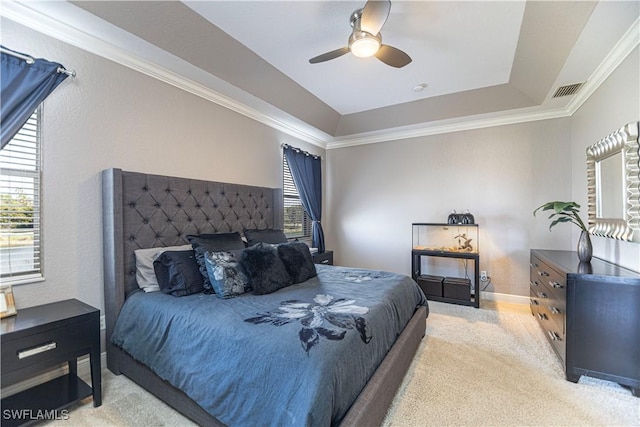 carpeted bedroom featuring ceiling fan, ornamental molding, a raised ceiling, and visible vents