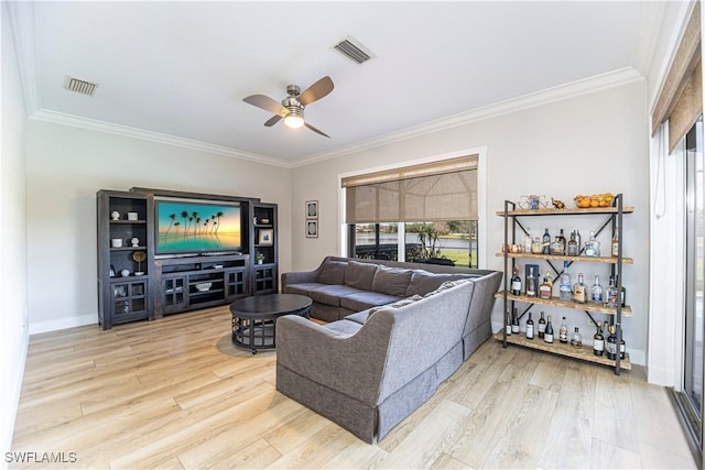 living area with visible vents, baseboards, ceiling fan, wood finished floors, and crown molding