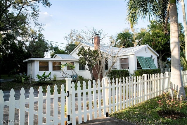 view of front of home featuring a fenced front yard and a chimney