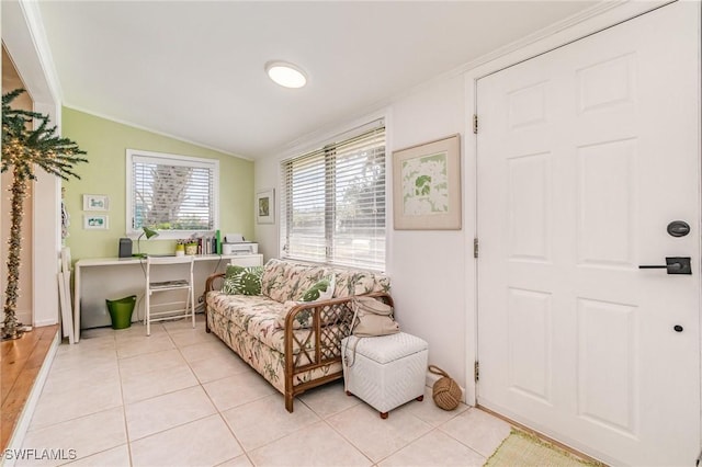 living area featuring light tile patterned floors, ornamental molding, and vaulted ceiling