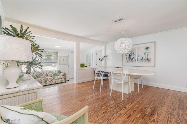 dining room with baseboards, visible vents, and wood finished floors