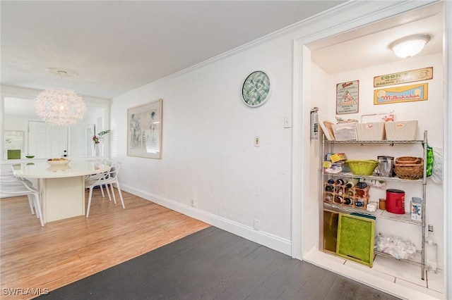 kitchen with baseboards, crown molding, wood finished floors, and a kitchen breakfast bar