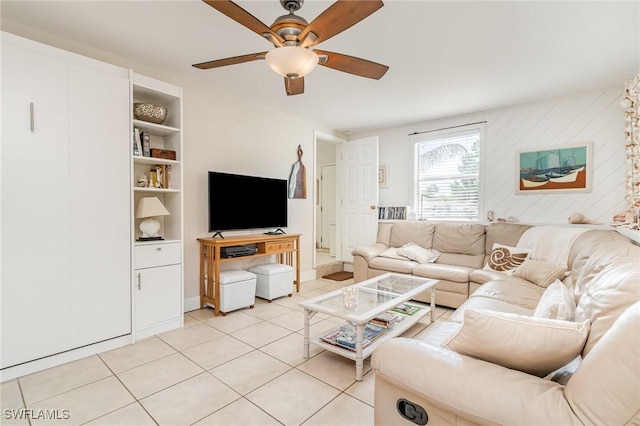 living room with built in features, a ceiling fan, and light tile patterned flooring