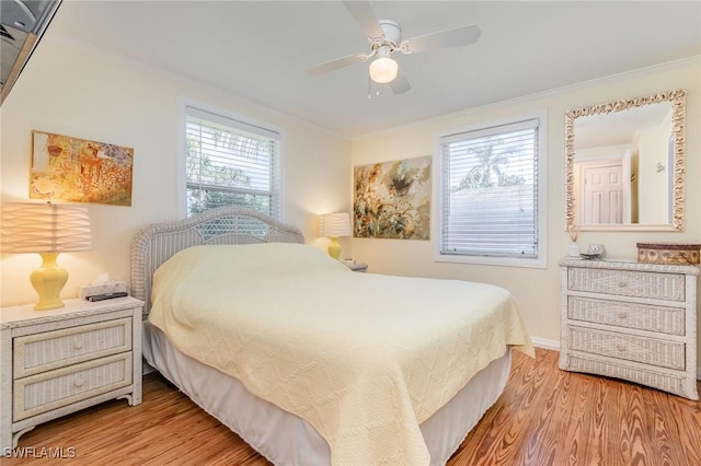 bedroom with ceiling fan, baseboards, light wood-style flooring, and crown molding