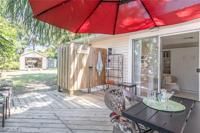 wooden deck featuring an outbuilding and outdoor dining space