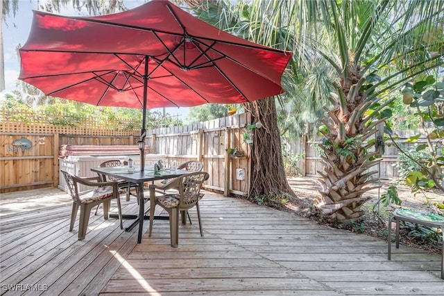 deck with a fenced backyard and outdoor dining area