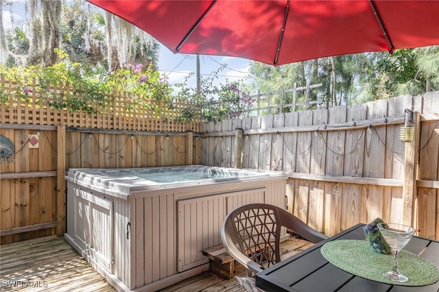 wooden deck featuring fence and a hot tub