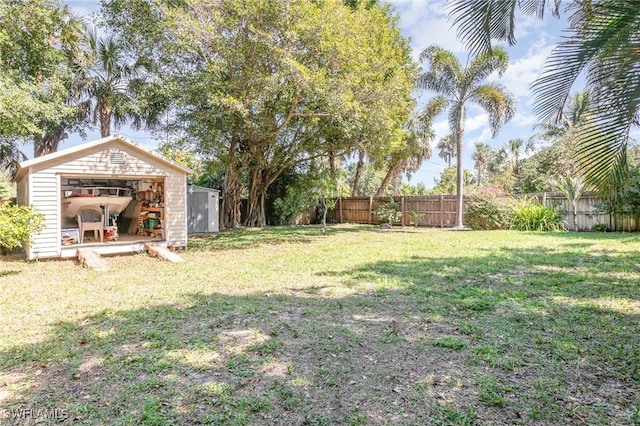 view of yard featuring a fenced backyard, an outdoor structure, and a shed