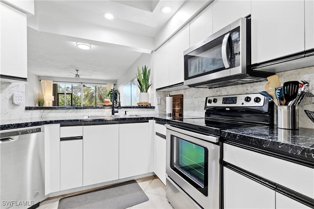 kitchen with decorative backsplash, white cabinets, modern cabinets, appliances with stainless steel finishes, and a sink