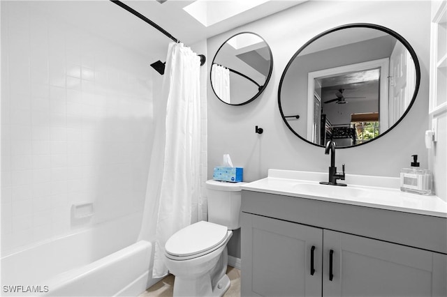 bathroom featuring shower / bath combo with shower curtain, vanity, toilet, and a ceiling fan