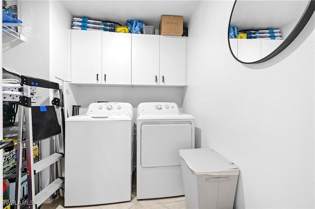 clothes washing area with washer and dryer and cabinet space