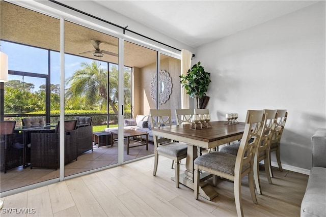 dining room featuring ceiling fan, light wood-style flooring, and baseboards