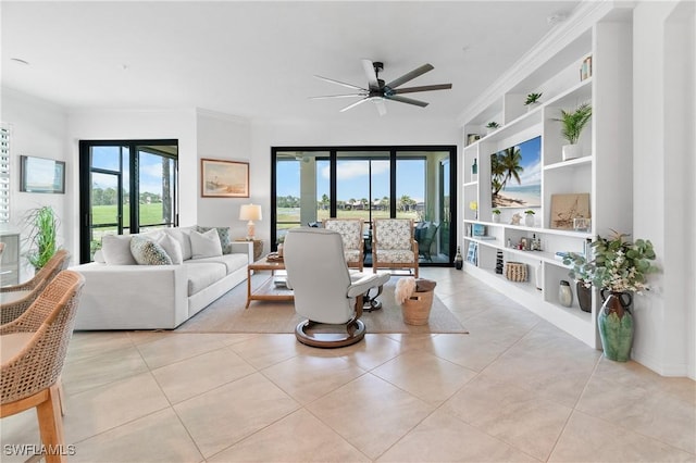 living room featuring light tile patterned flooring, built in features, a ceiling fan, and crown molding