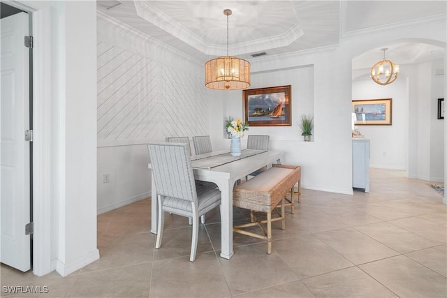 dining area with a chandelier, arched walkways, light tile patterned flooring, a raised ceiling, and crown molding