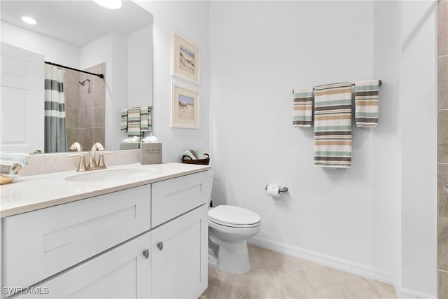 bathroom featuring toilet, vanity, tile patterned flooring, tiled shower, and baseboards