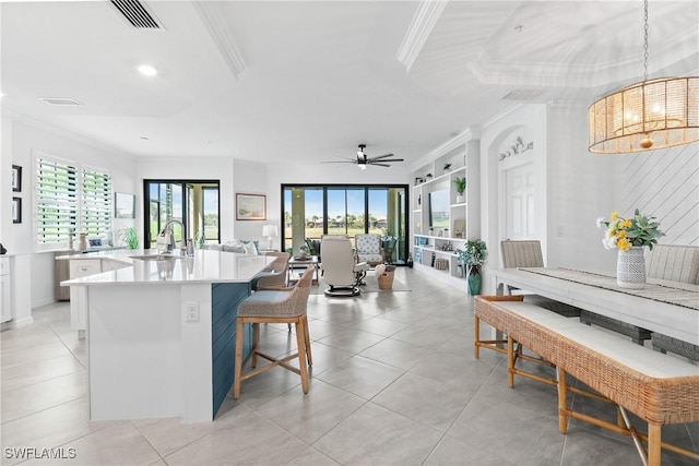 kitchen with visible vents, crown molding, and a sink