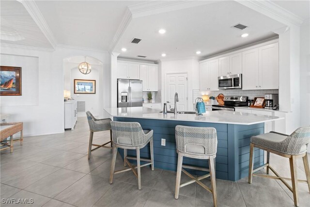 kitchen featuring stainless steel appliances, visible vents, backsplash, and a kitchen bar