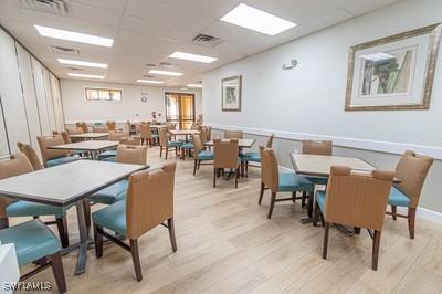 dining area featuring a drop ceiling, visible vents, and light wood finished floors