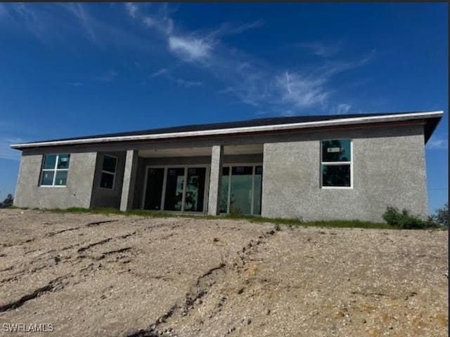 rear view of house with stucco siding