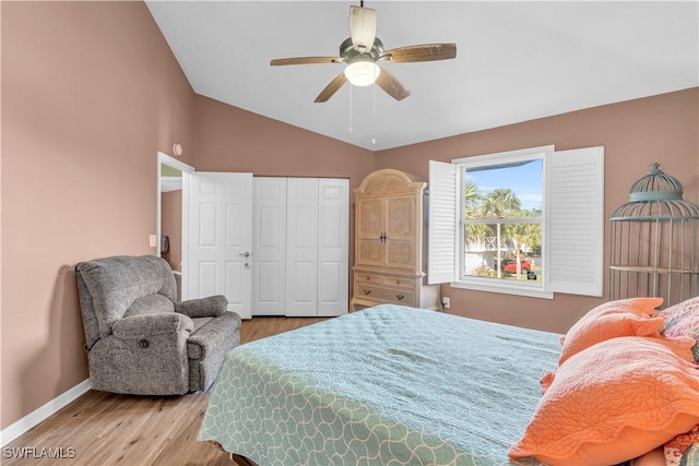 bedroom with baseboards, a ceiling fan, wood finished floors, vaulted ceiling, and a closet